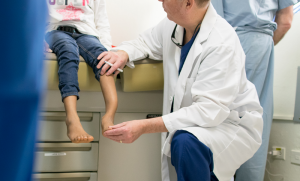 Physician Bauer examining patient foot.