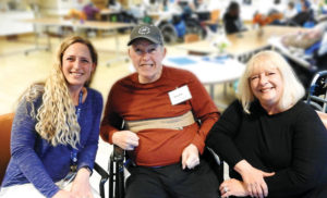 Donna Rawon, right, is the primary caregiver for her husband, Ralph Rawson. In 2016, he had his second stroke, which impacted his entire right side, including his ability to eat and swallow. Last January, he had another stroke (his third) that affected his peripheral vision. Next to them is Sara Spinner, program director, The Adult Day Center at St. Camillus, where Ralph is a registrant. Photo courtesy of Deborah Christiansen, The Centers at St. Camillus.  