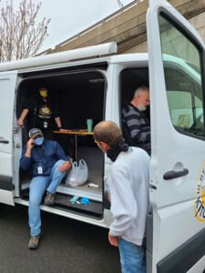 With van parked, physician David Lehmann puts his “bread and butter medicine” to work as he treats various homless individuals 